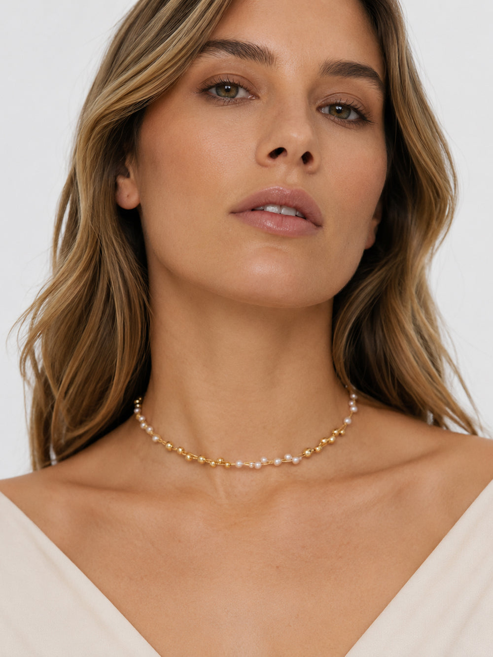 Alyssa gold pearl lariat necklace styled close to the neckline