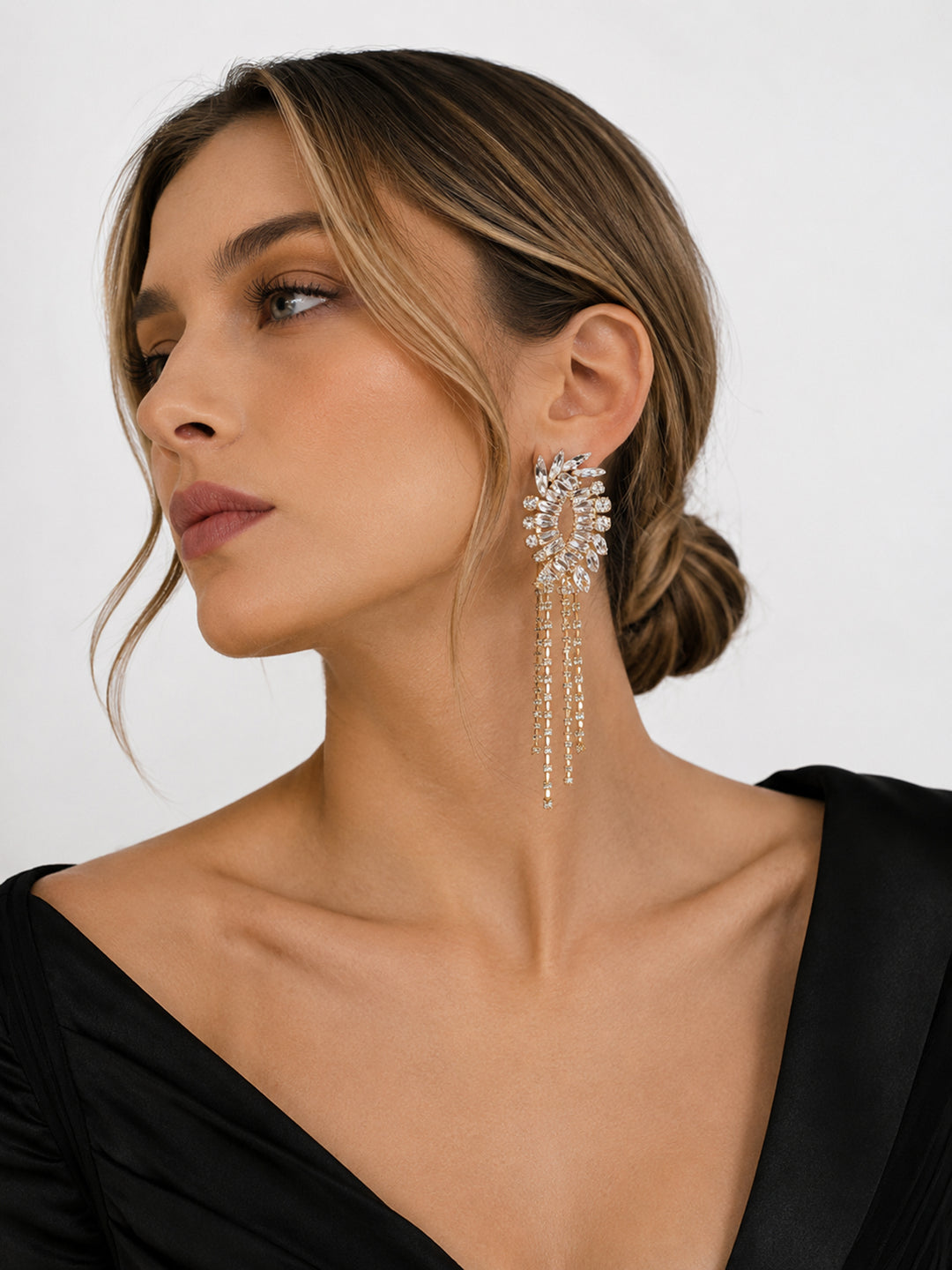 Long crystal statement earrings worn with black dress