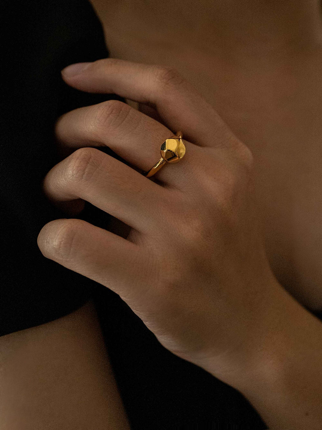a hand wear A gold ring in the shape of a rock