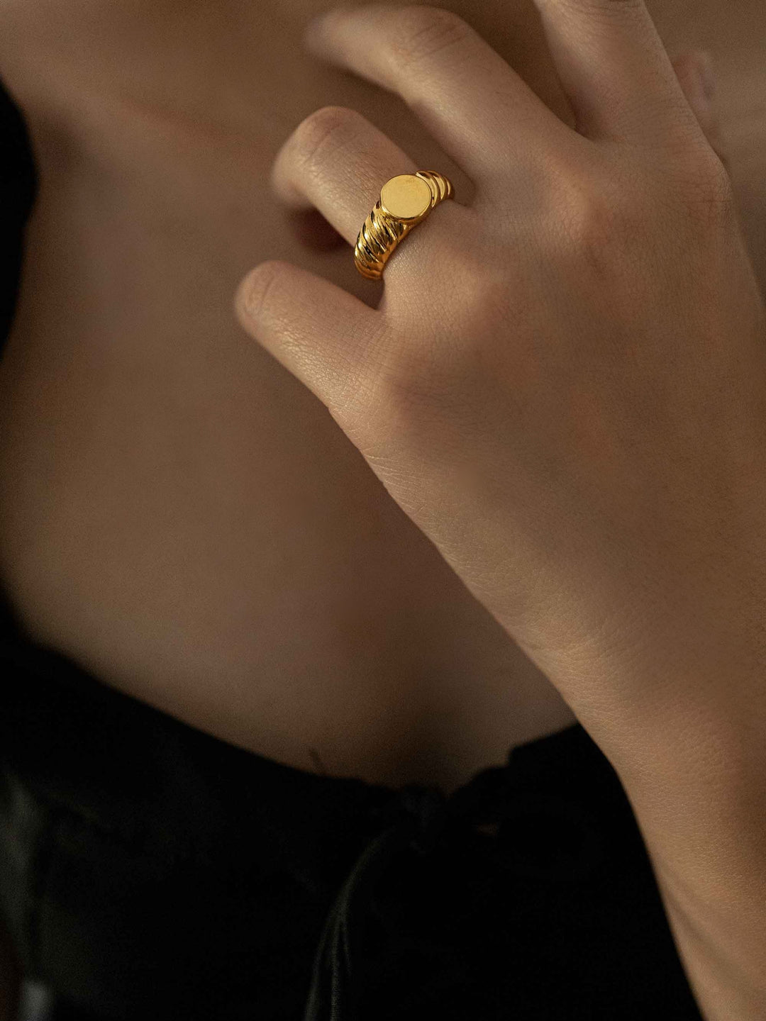 a hand wear A gold ring with a spiral pattern