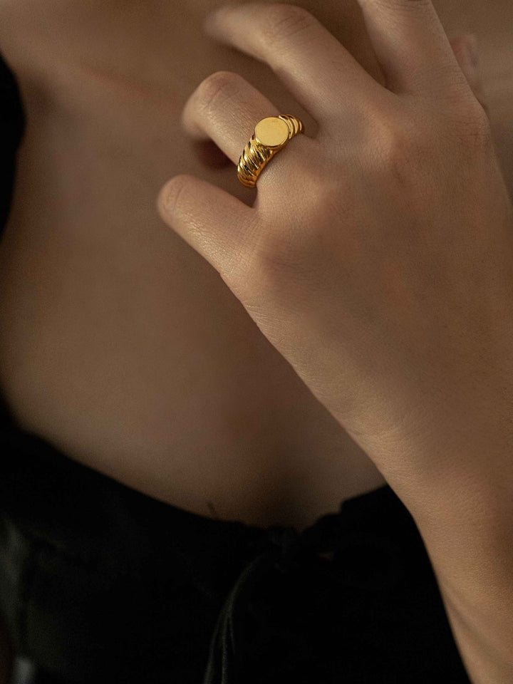 a hand wear A gold ring with a spiral pattern