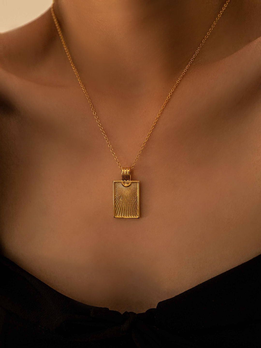 a model wear A gold necklace with a rectangular pendant