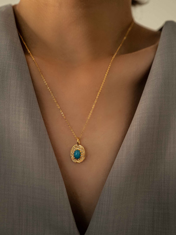 a model wear An oval pendant gold necklace