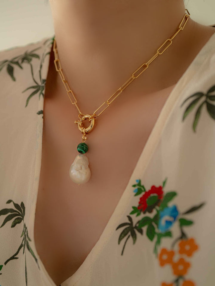 Model with a gold necklace with baroque pearls and malachite