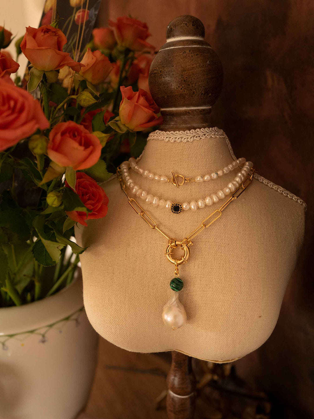 A gold necklace with baroque pearls and malachite