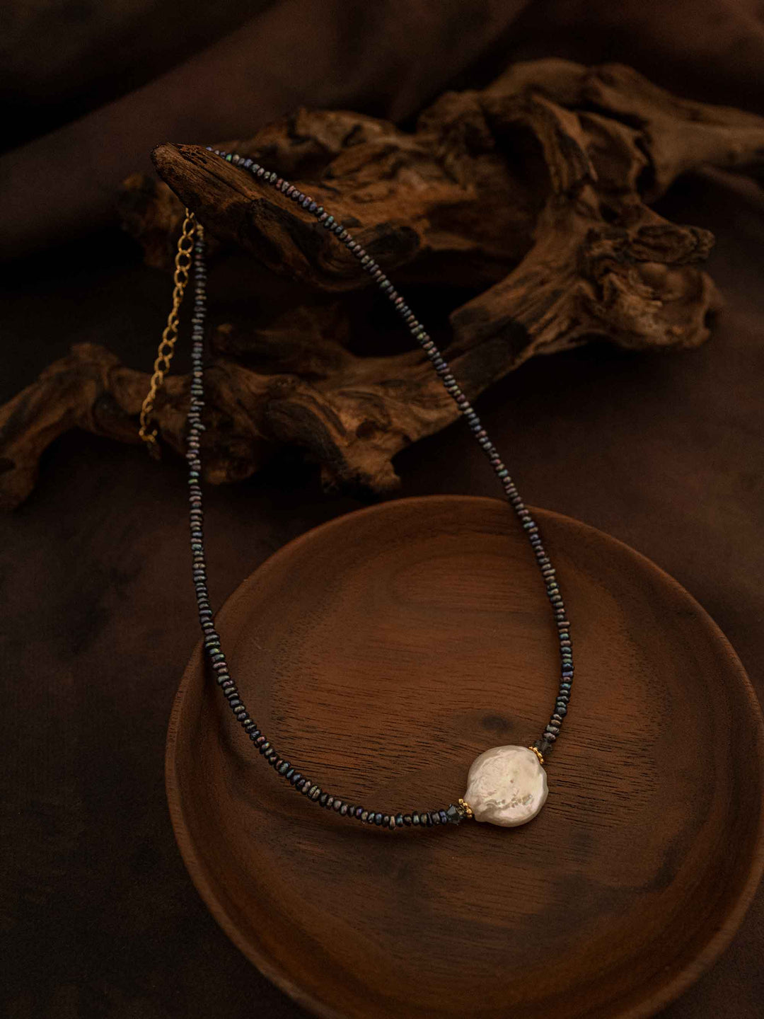 A handmade beaded necklace with abalone shells and baroque pearls