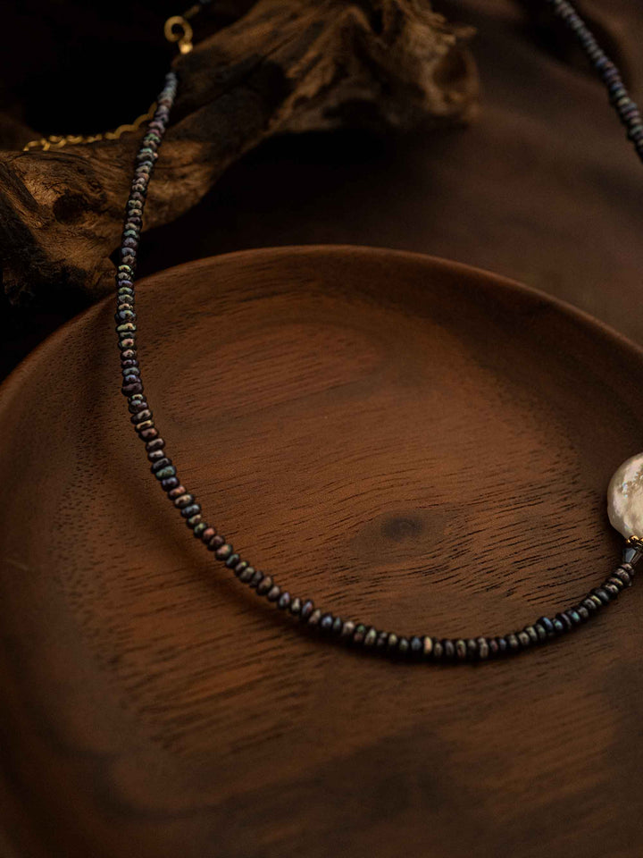 A handmade beaded necklace with abalone shells and baroque pearls