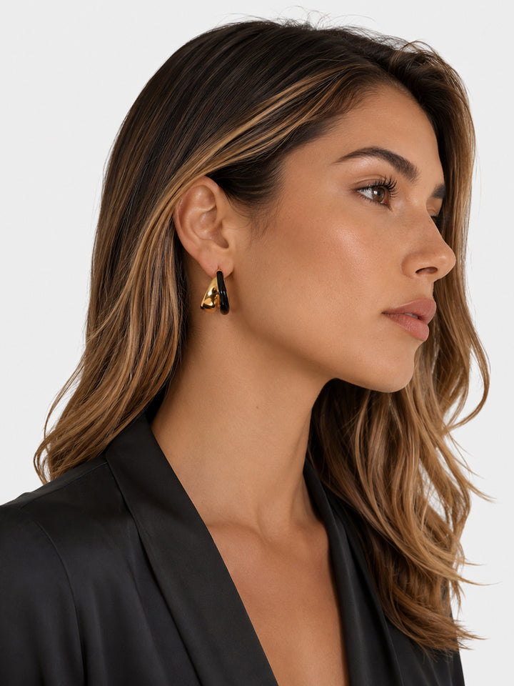 Black enamel hoop earrings worn with black blazer