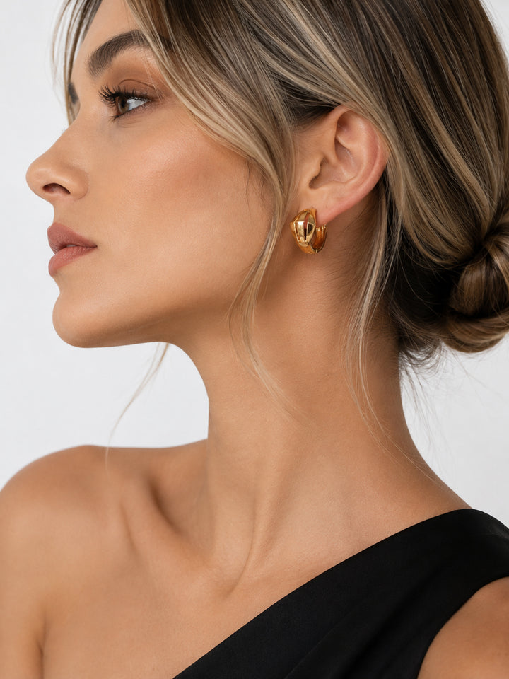 Gold-plated openwork hoop earrings worn with black outfit