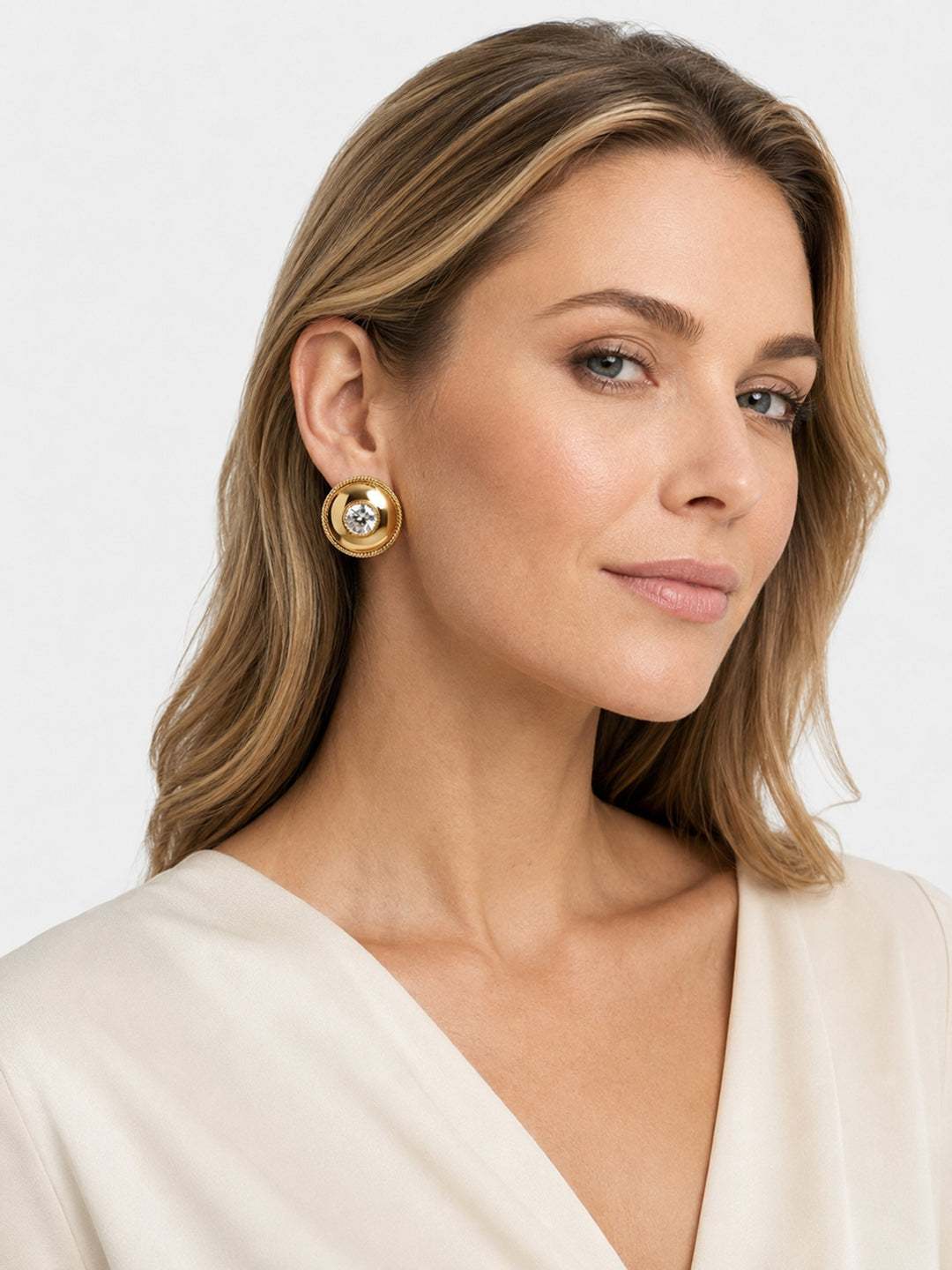 Gold-plated crystal stud earrings worn with black outfit