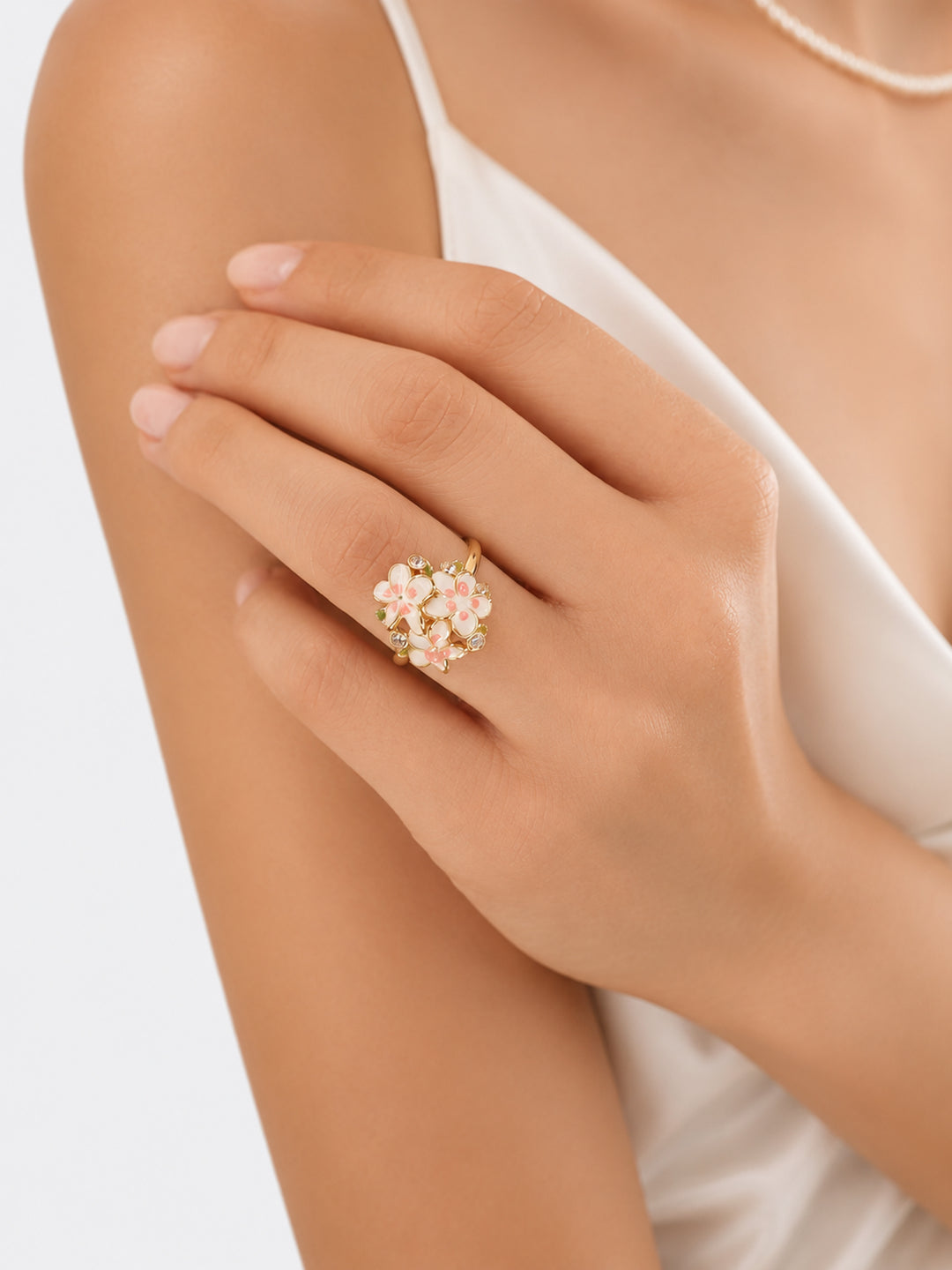 Gold-plated enamel flower ring worn with white outfit