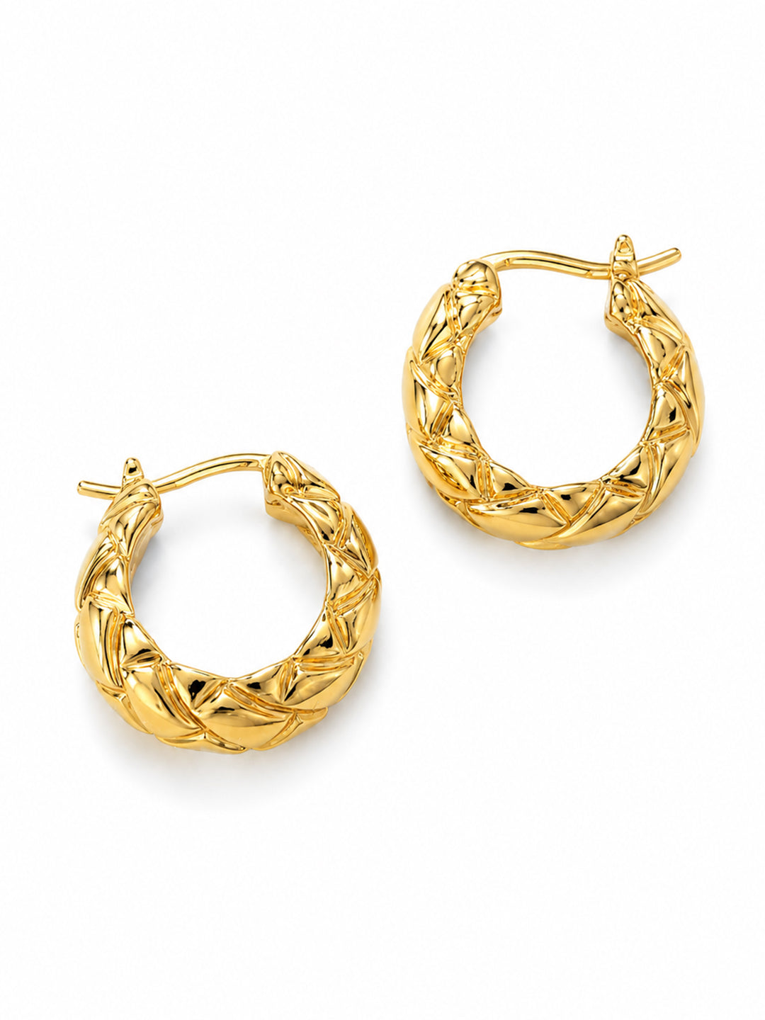 Braided gold hoop earrings on red satin