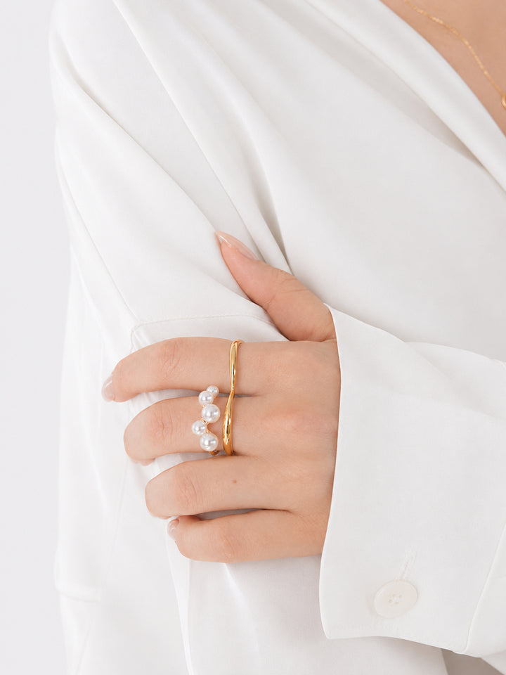 Gold-plated pearl ring worn with white outfit