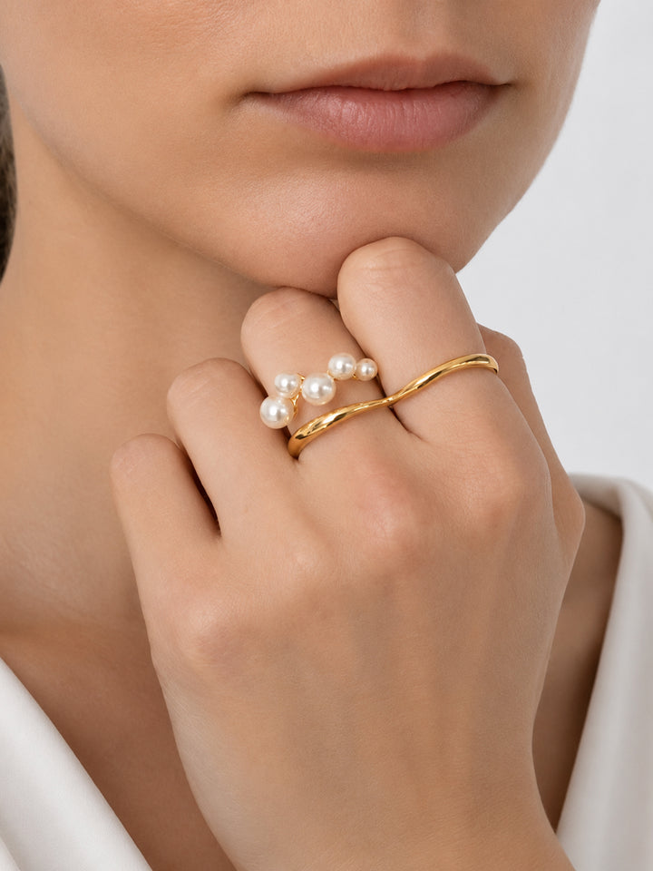 Gold-plated pearl ring worn with white outfit
