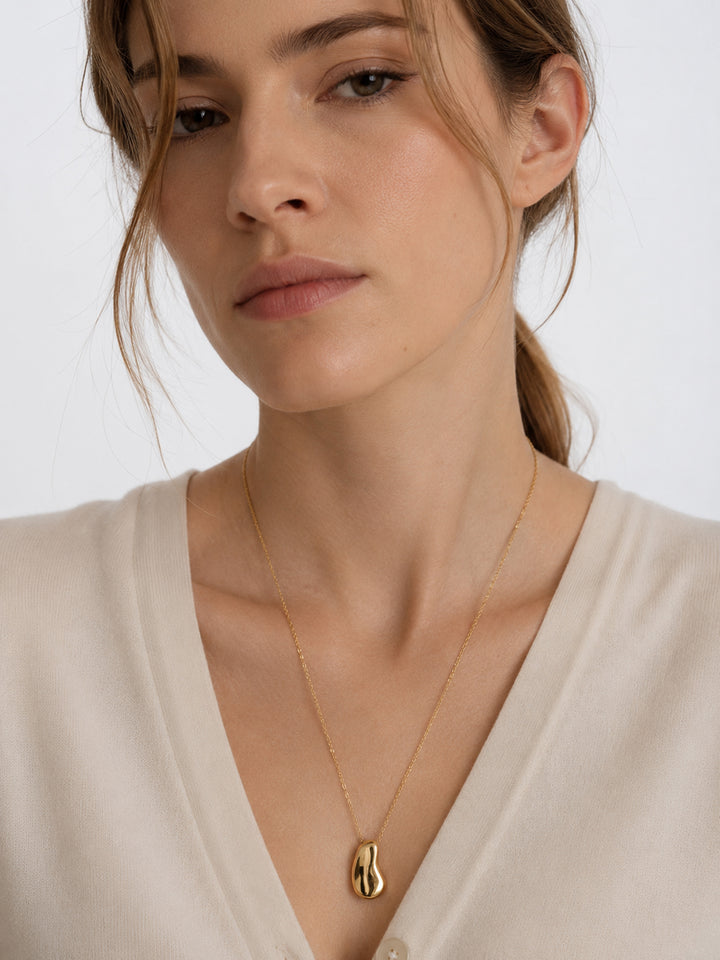 Kyra sculptural gold pendant necklace styled on model