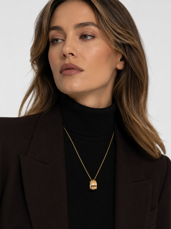 Meliora gold pendant necklace styled with black turtleneck
