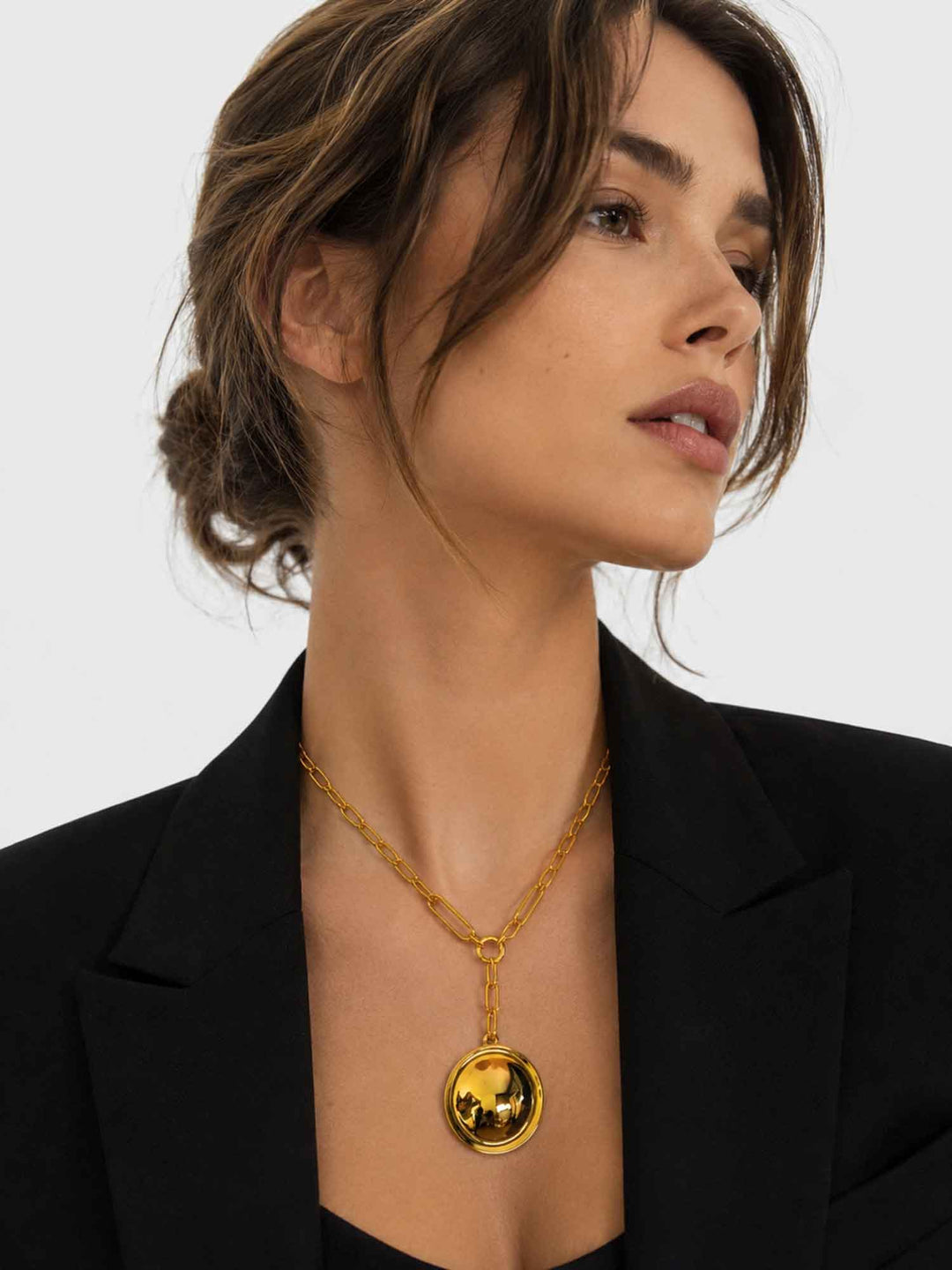 Close-up view of model wearing Inez detachable round pendant gold necklace