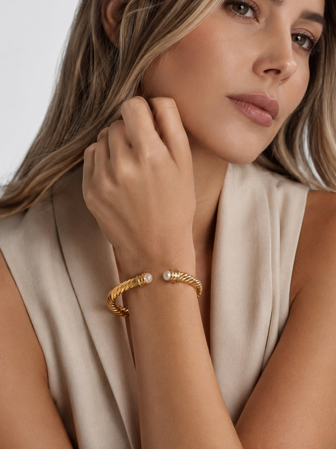 Gold-plated pearl cuff bracelet worn with neutral outfit