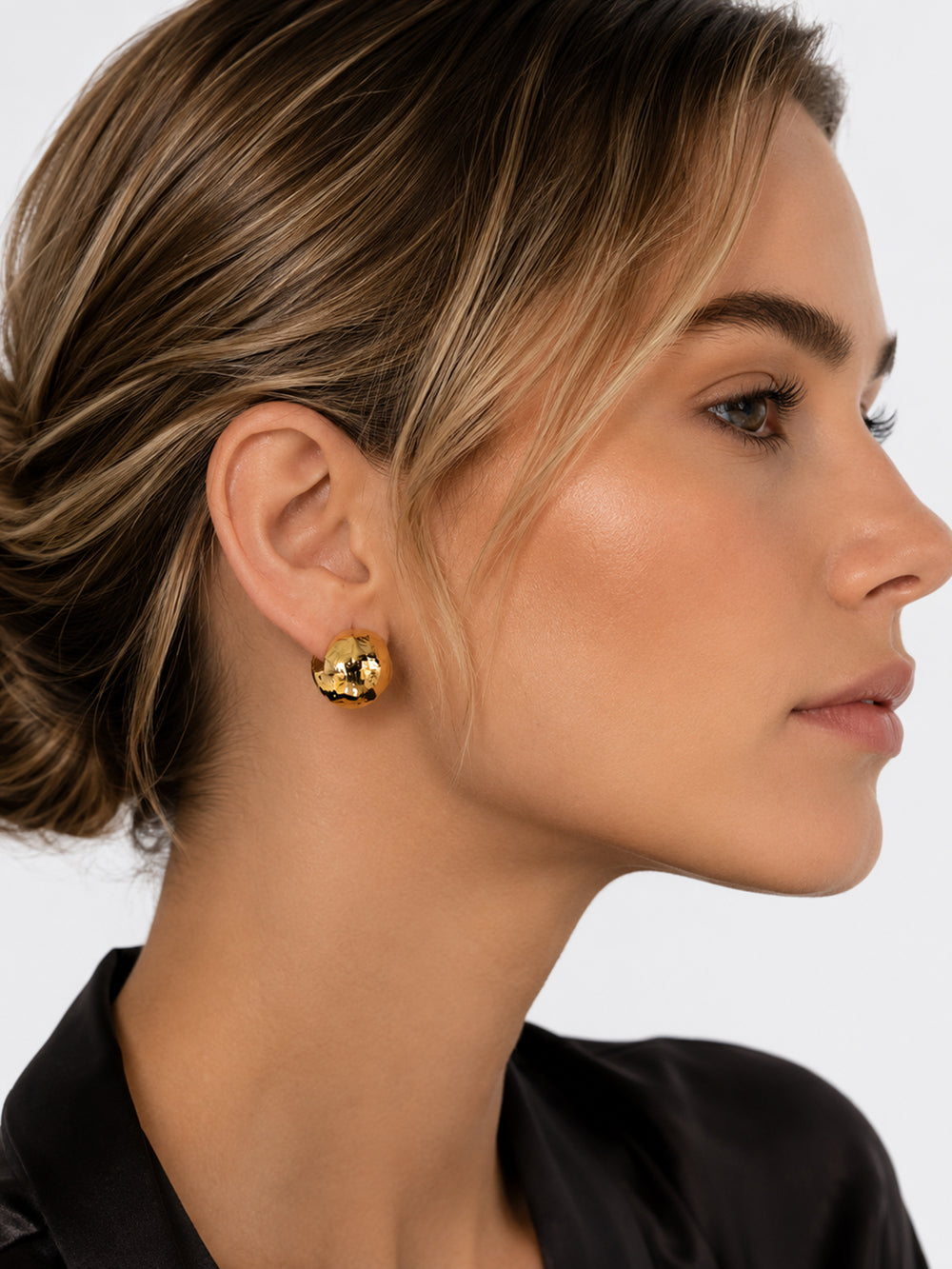 Oleana sculptural gold stud earrings on model
