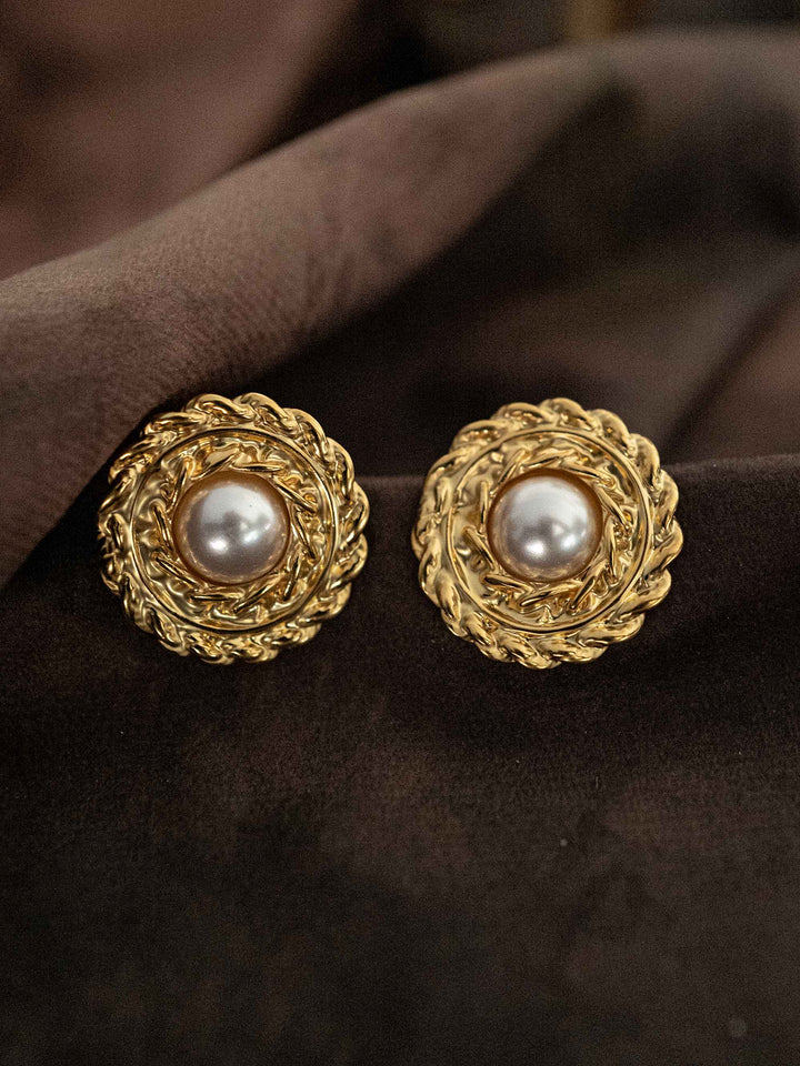 A round gold earring with a pearl in the center.