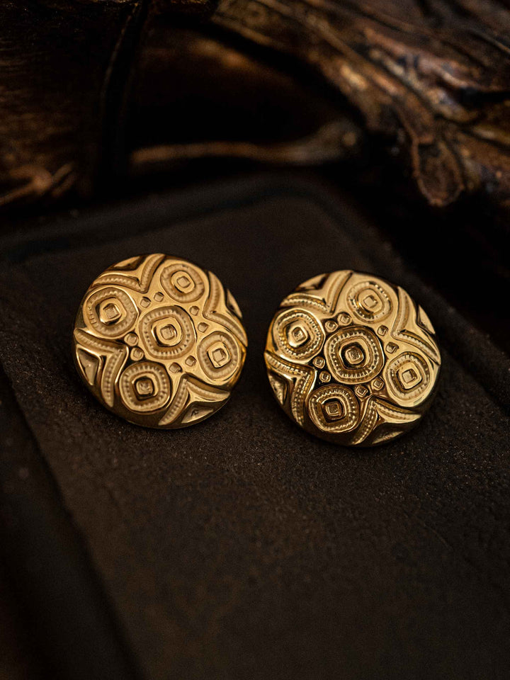 A gold earring with a circular totem motif