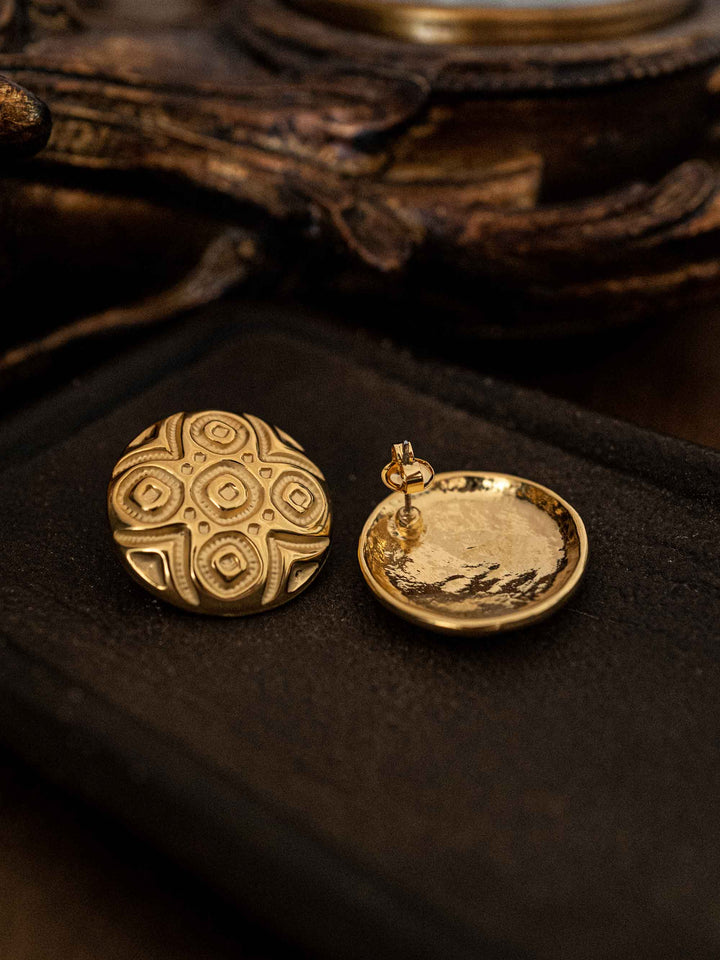 A gold earring with a circular totem motif