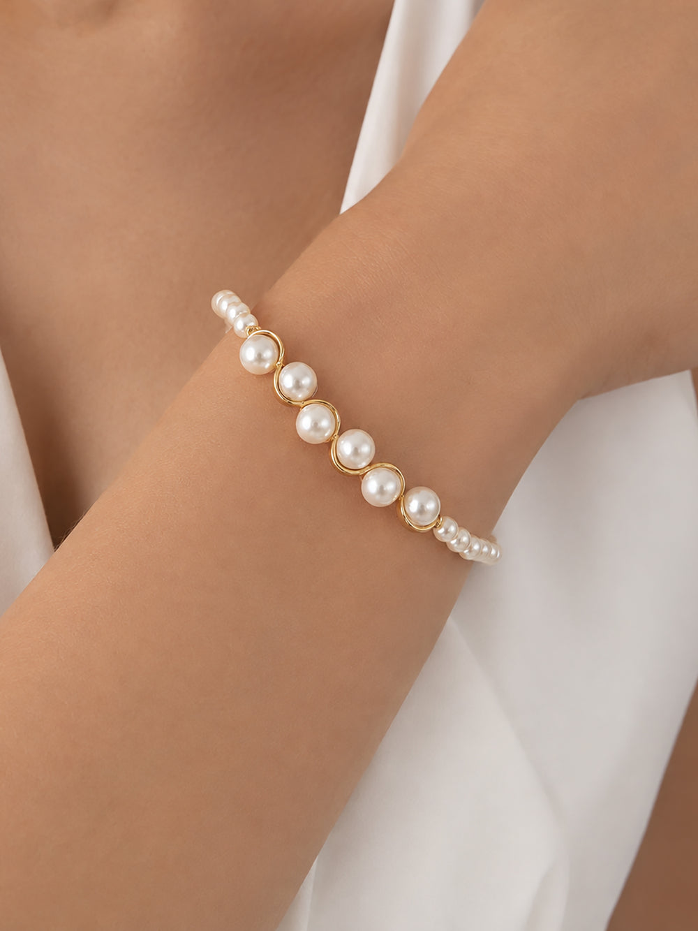 Glass pearl bracelet worn with white dress