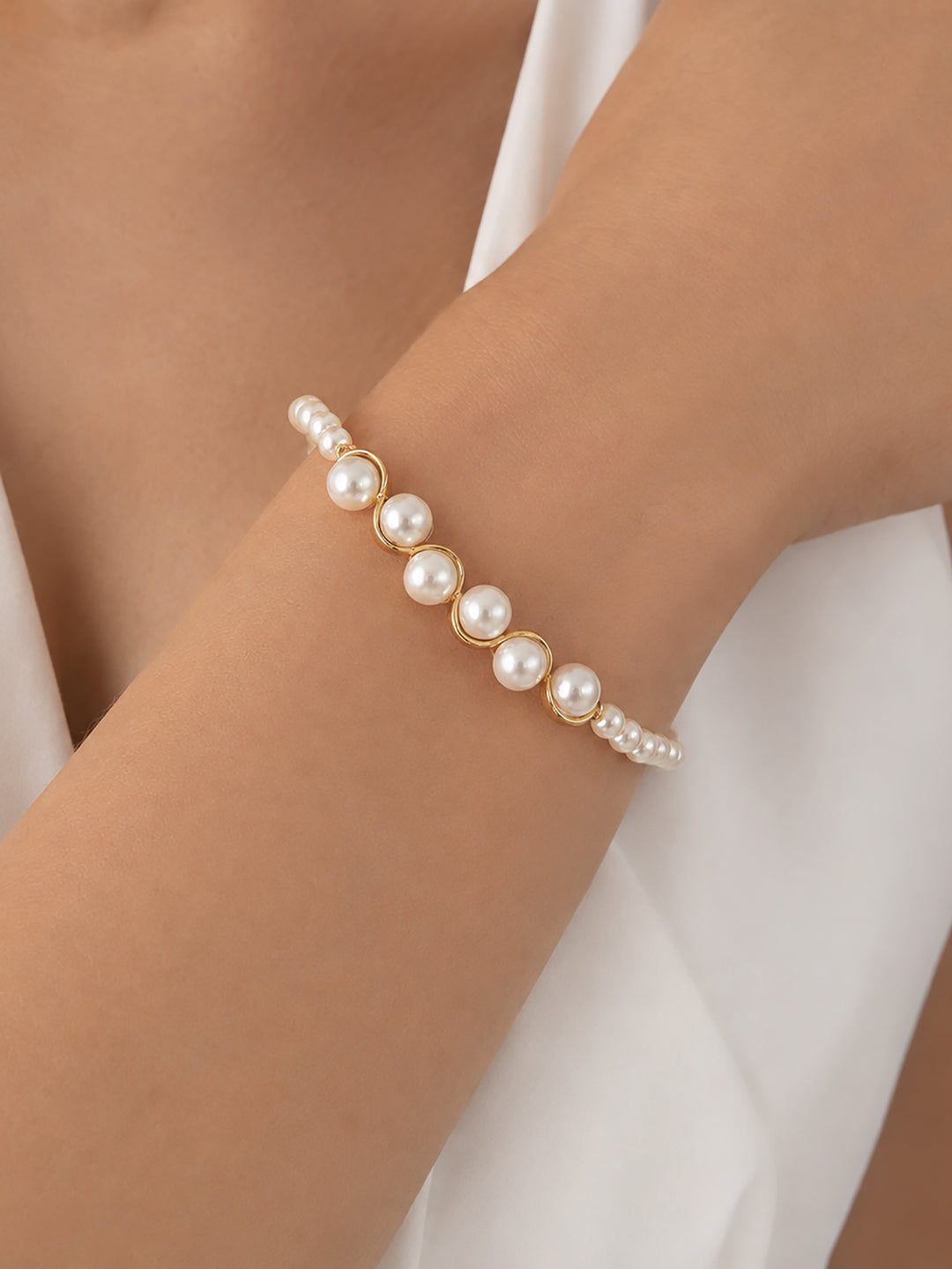Glass pearl bracelet worn with white dress