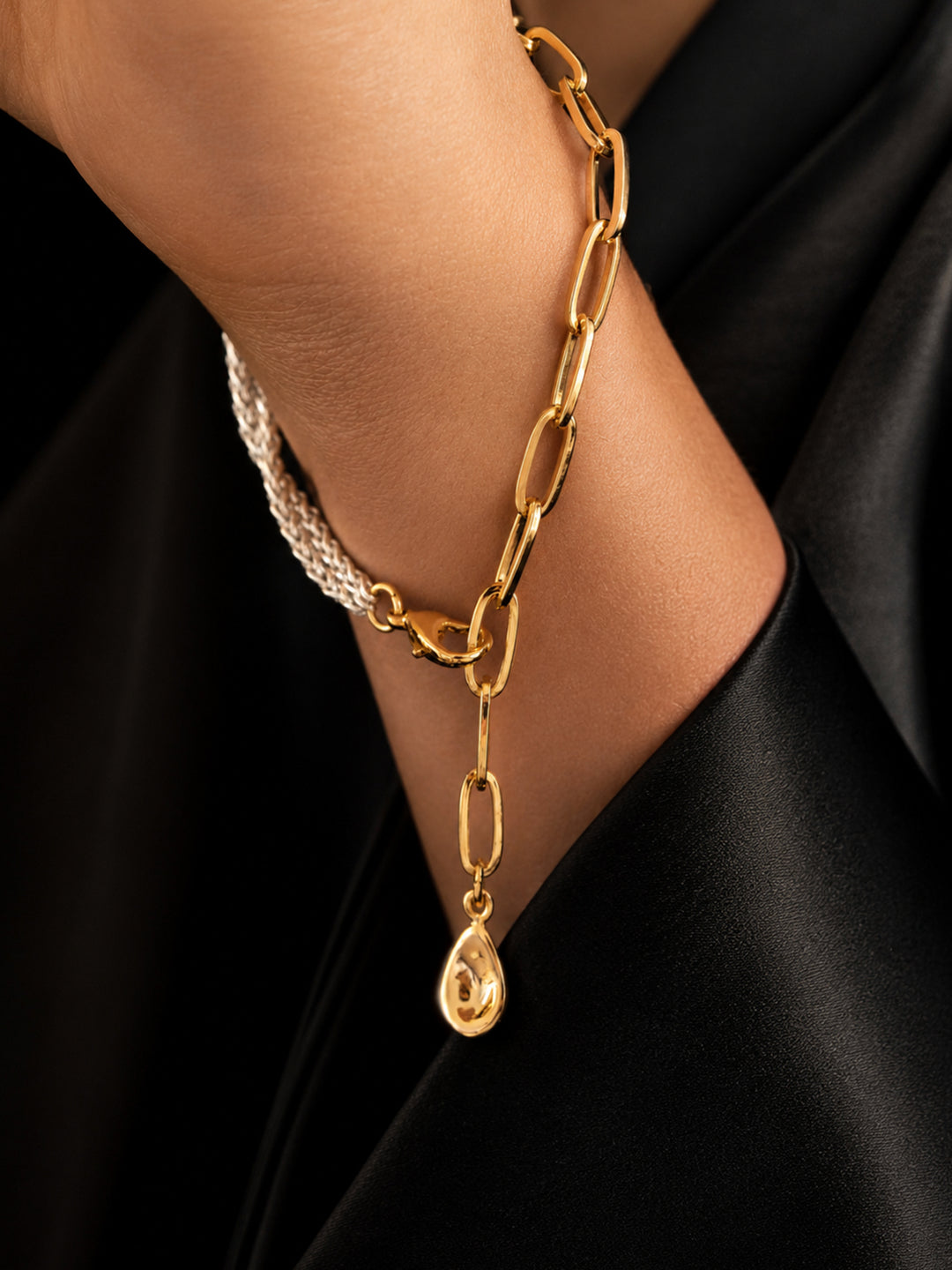 Mixed-metal chain bracelet worn with black outfit