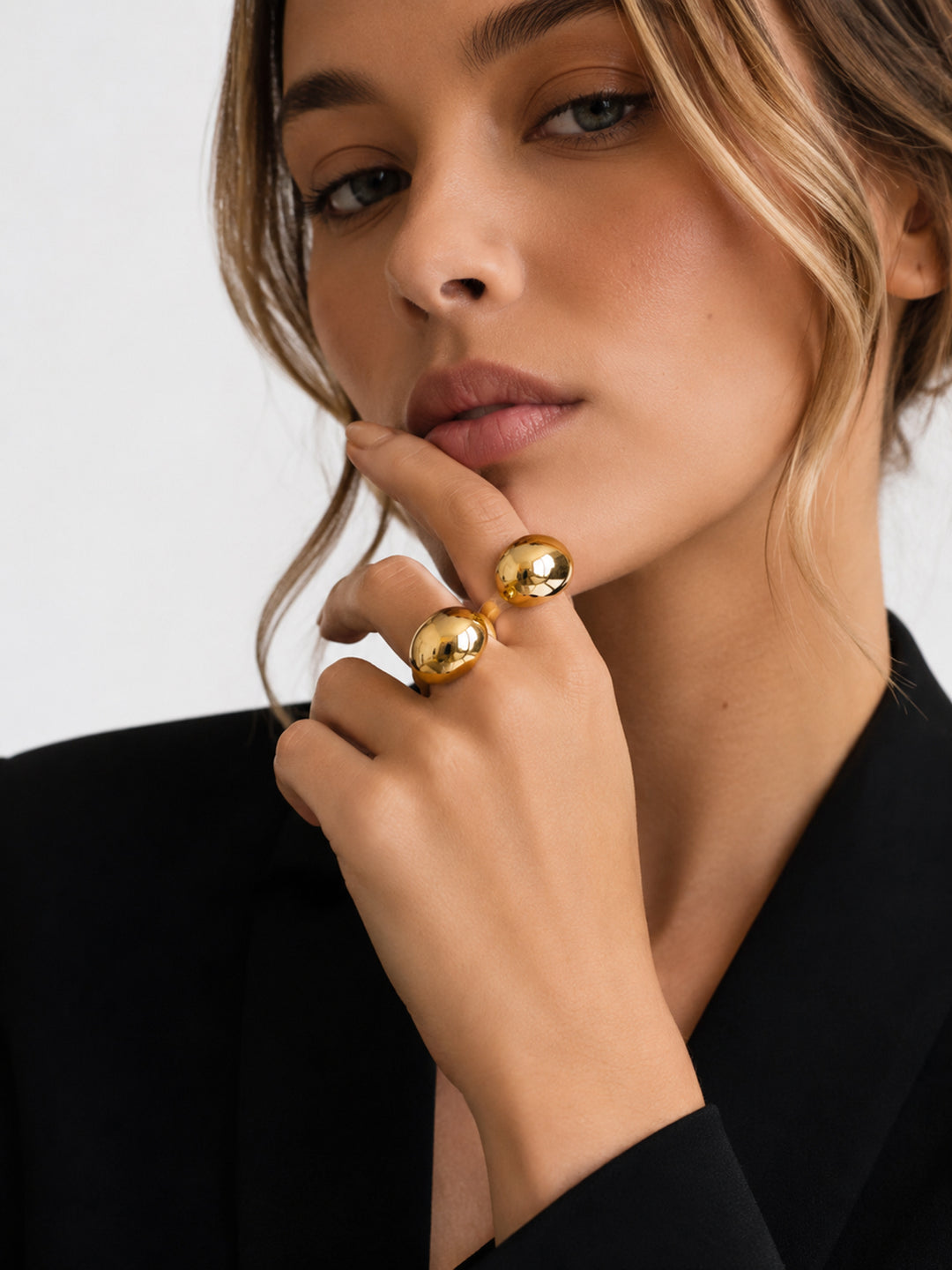 Gold-plated sculptural ring worn with black outfit