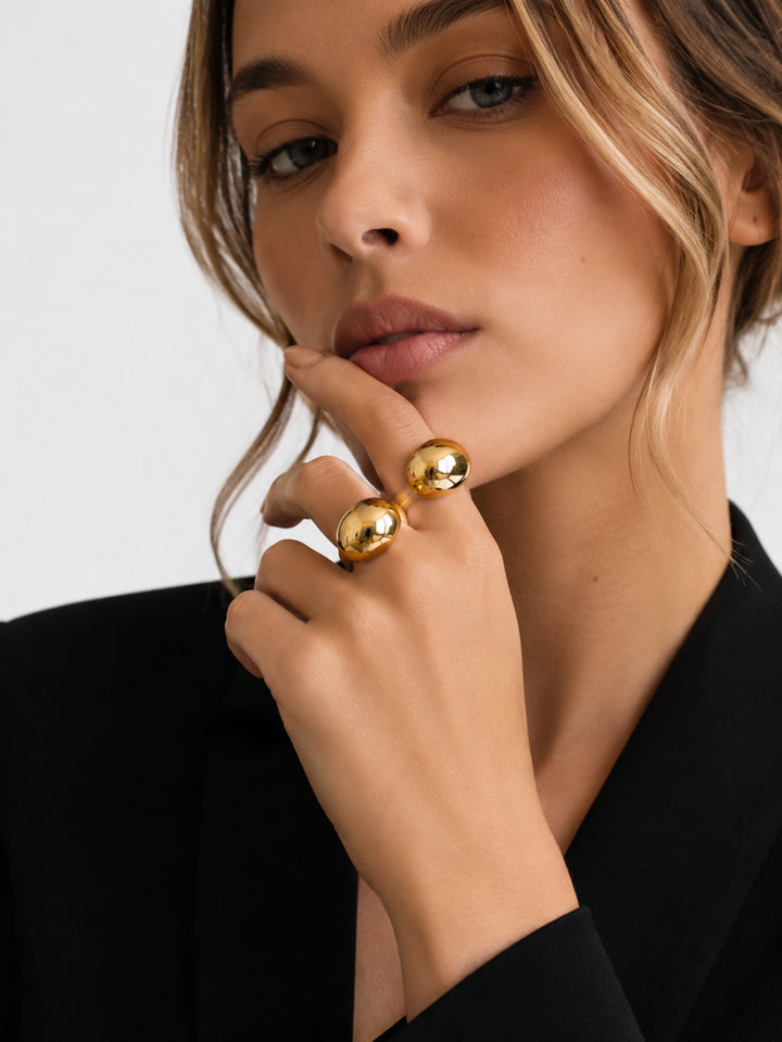 Gold-plated sculptural ring worn with black outfit