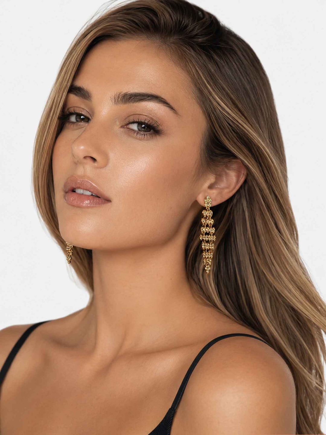 Model wearing Adele gold crystal statement drop earrings with evening styling