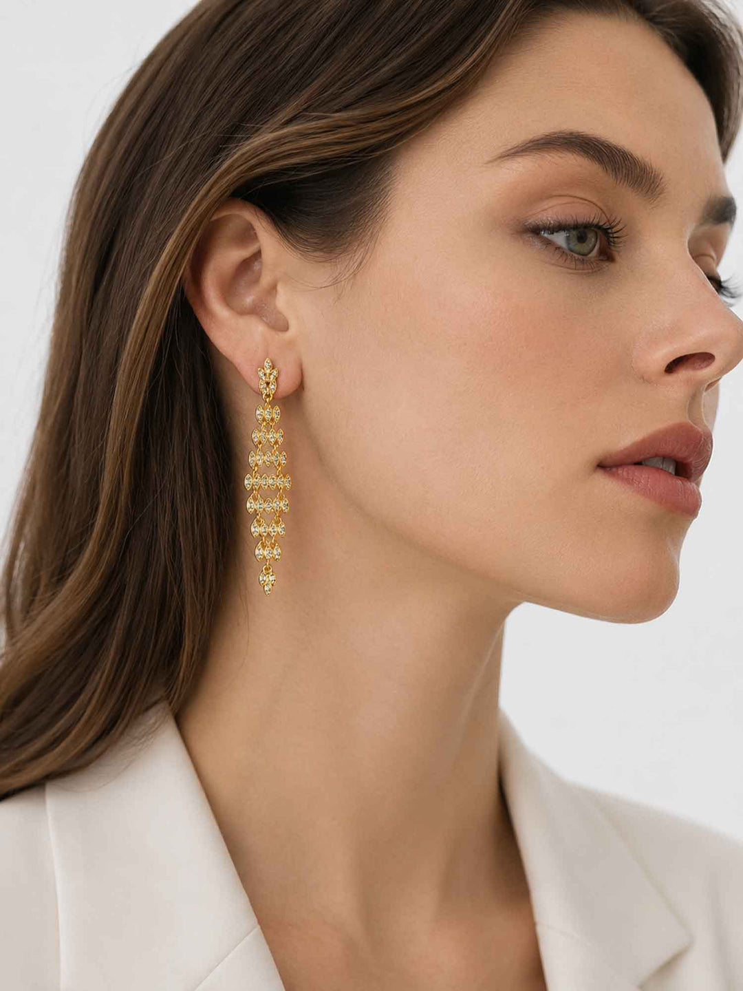 Side view of model wearing Adele gold crystal statement drop earrings