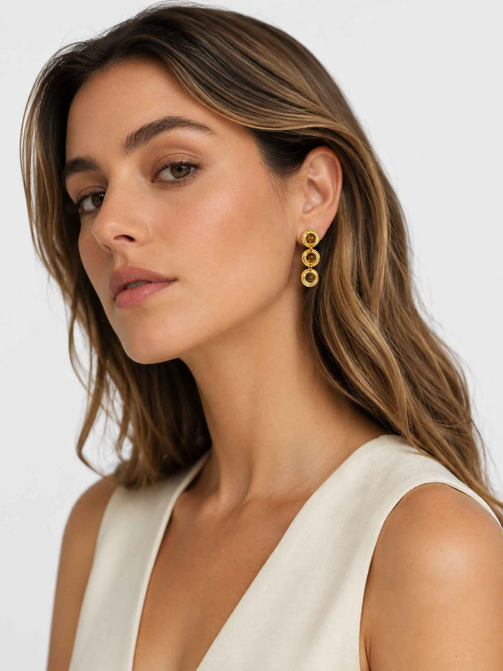 Side view of model wearing Alanis tiger eye gold drop earrings
