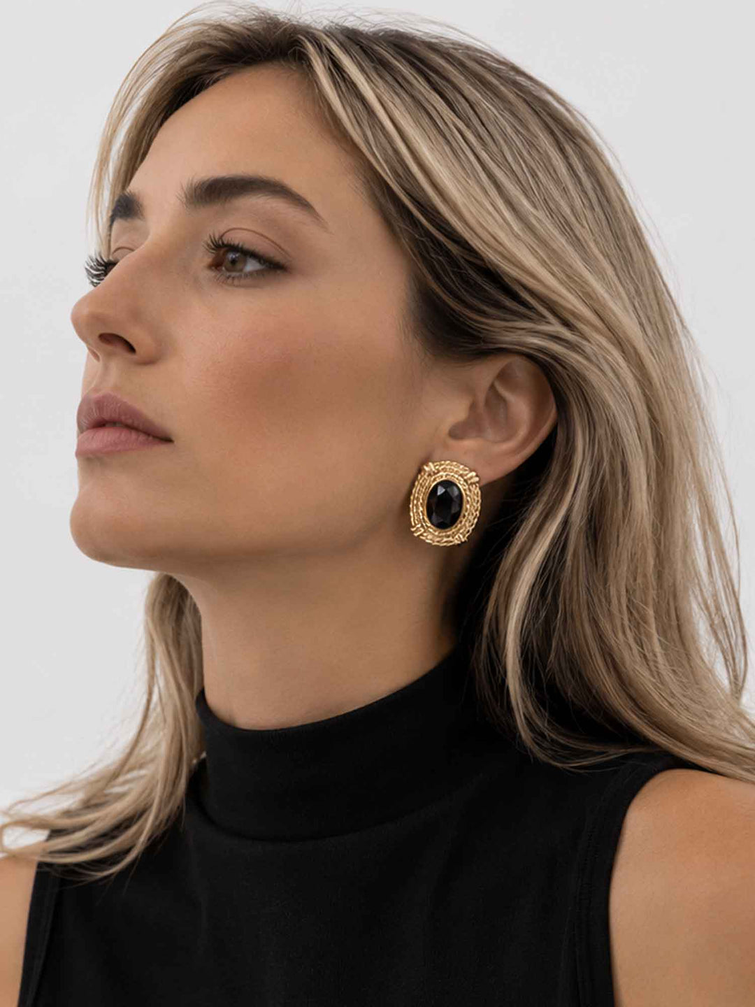 Side view of model wearing Atenea black glass statement earrings