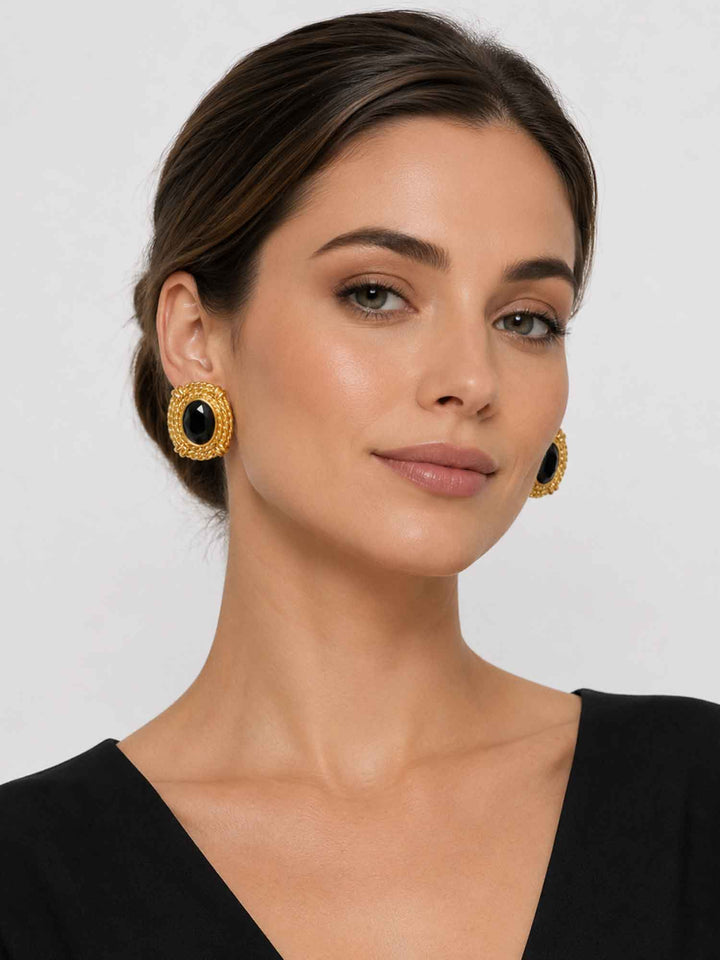 Model wearing black glass statement earrings with a polished evening look