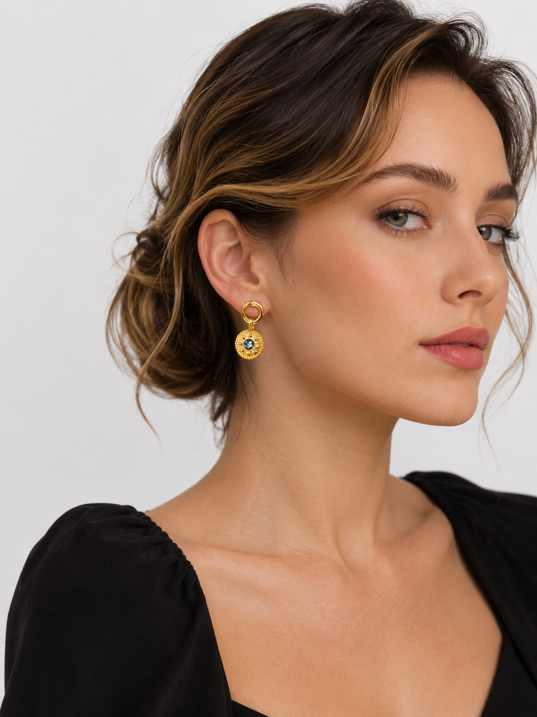 Close-up view of model wearing Celandine reversible black agate gold drop earrings