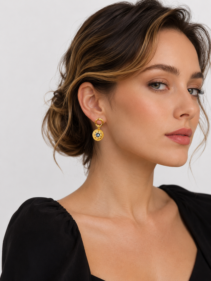 Close-up view of model wearing Celandine reversible black agate gold drop earrings