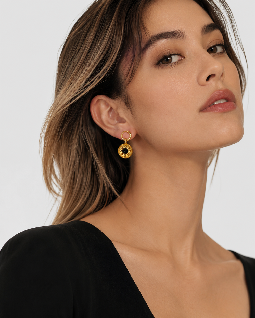Model wearing Celandine reversible black agate gold drop earrings with black outfit