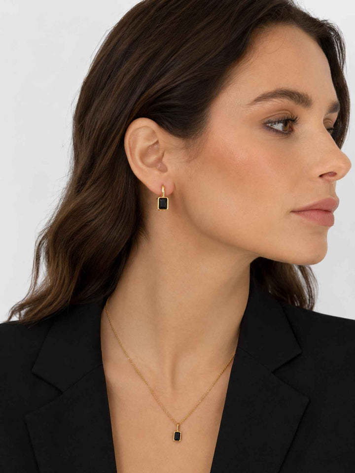 Side view of model wearing Clelia black cubic zirconia hoop earrings