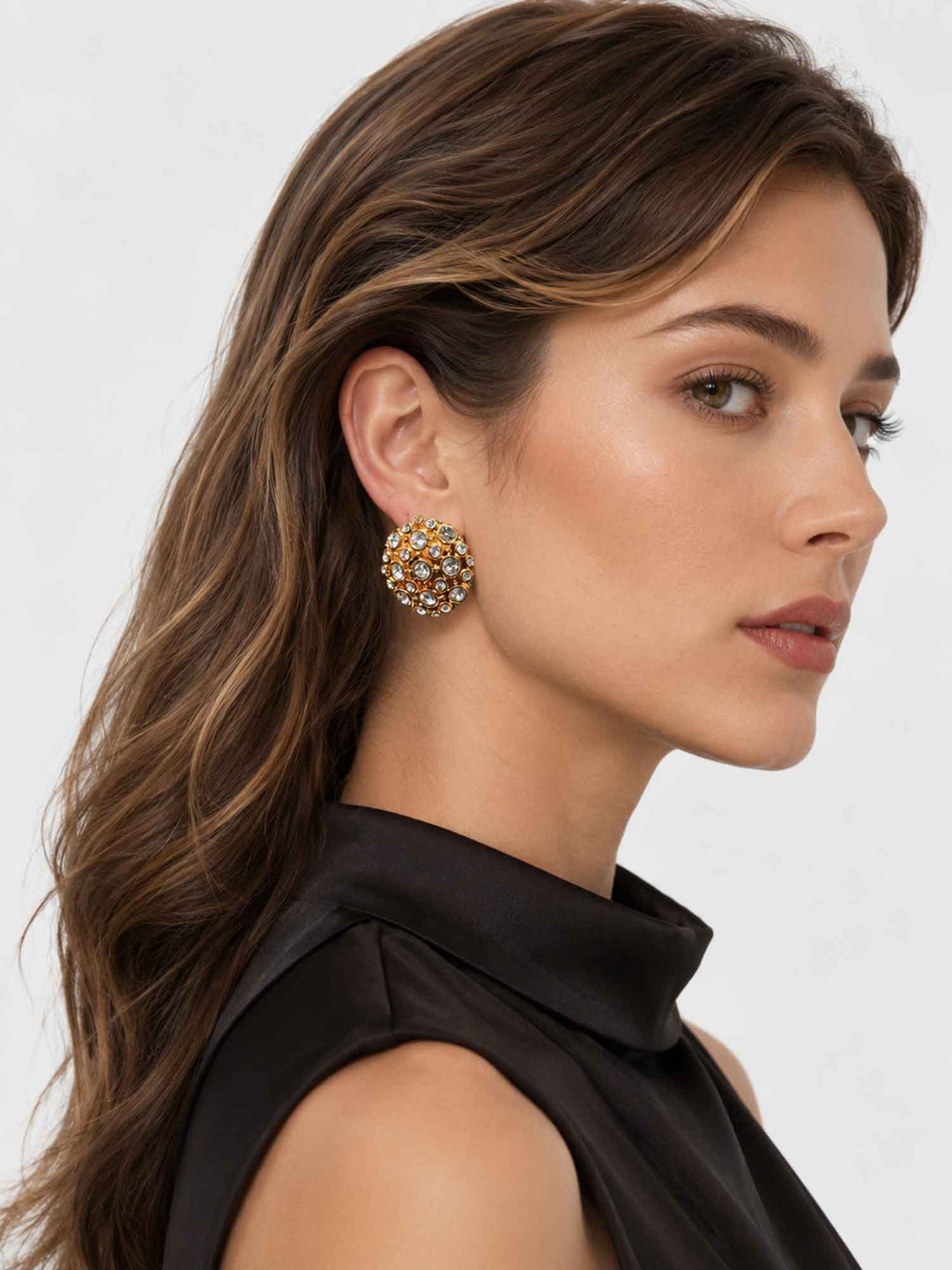 Model wearing Corisande gold cubic zirconia statement earrings with evening styling