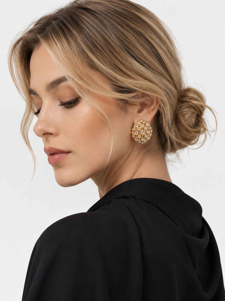 Side view of model wearing Corisande gold cubic zirconia statement earrings