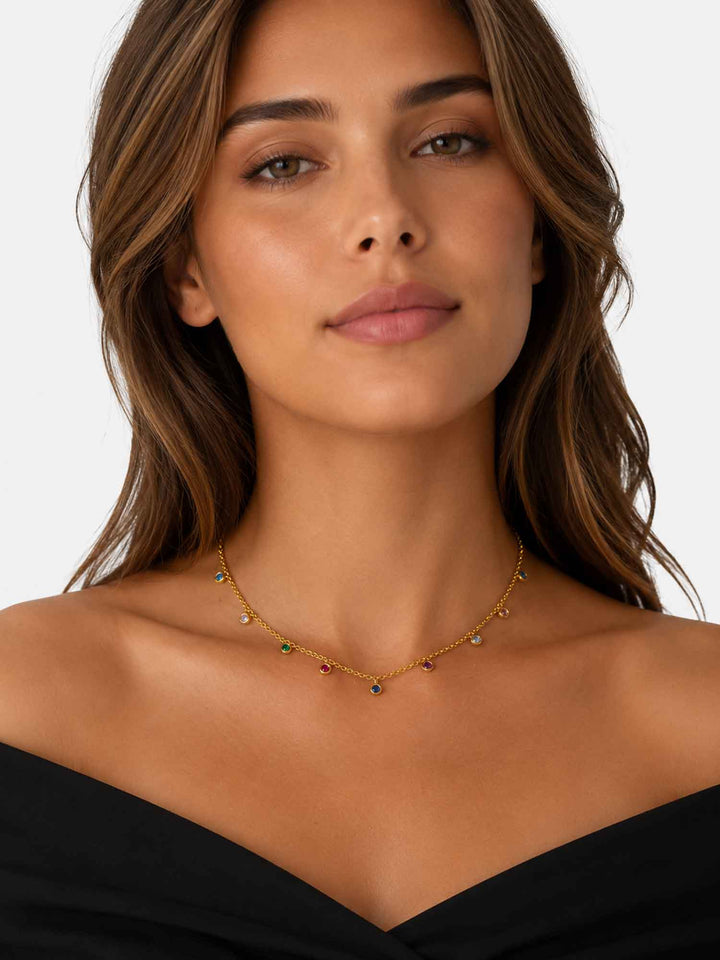 Model wearing Elowen multicolor cubic zirconia gold station necklace with black outfit