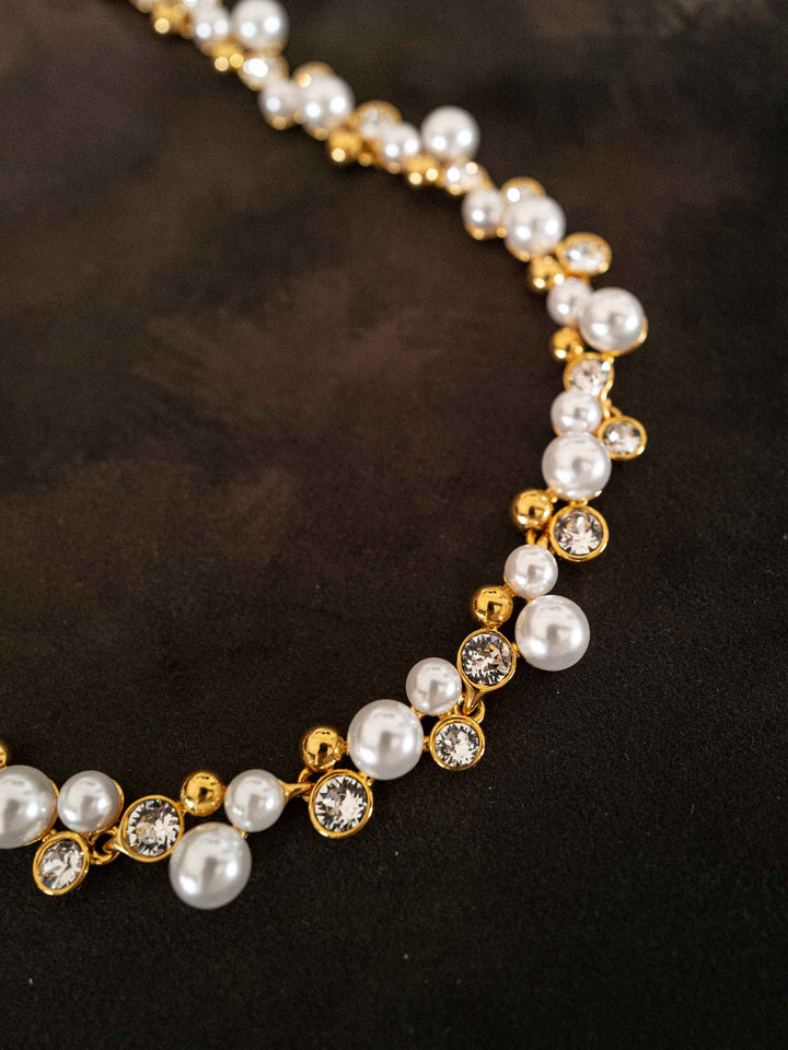Detail view of Elspeth imitation pearl glass crystal necklace styled on dark fabric