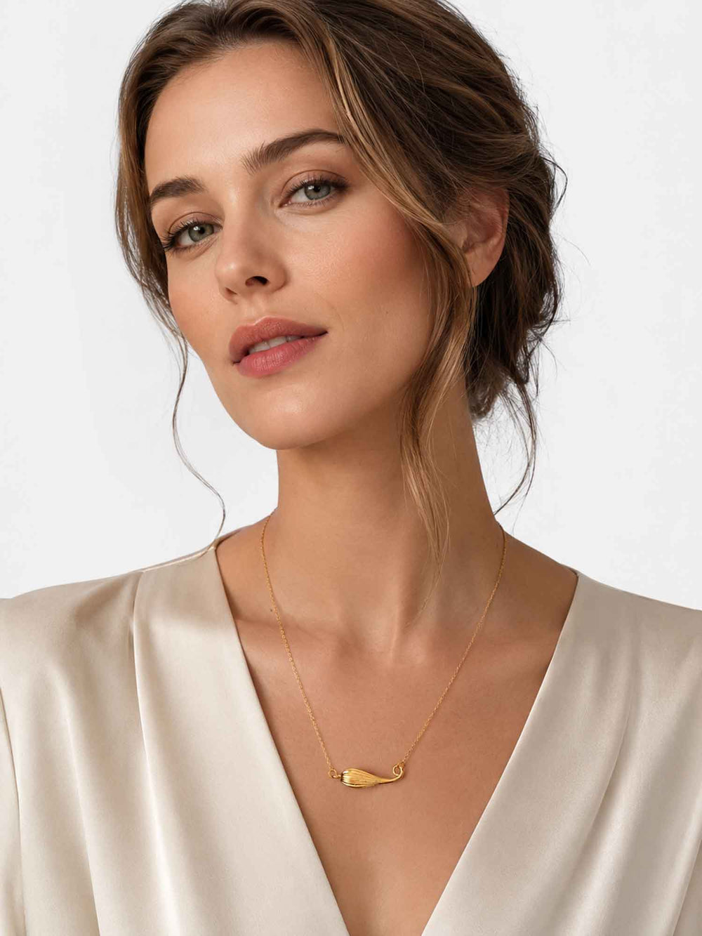 Model wearing Fernanda gold shell pendant necklace with white outfit