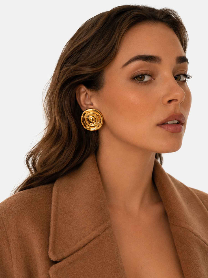 Model wearing Flowing Light gold statement stud earrings with brown outfit