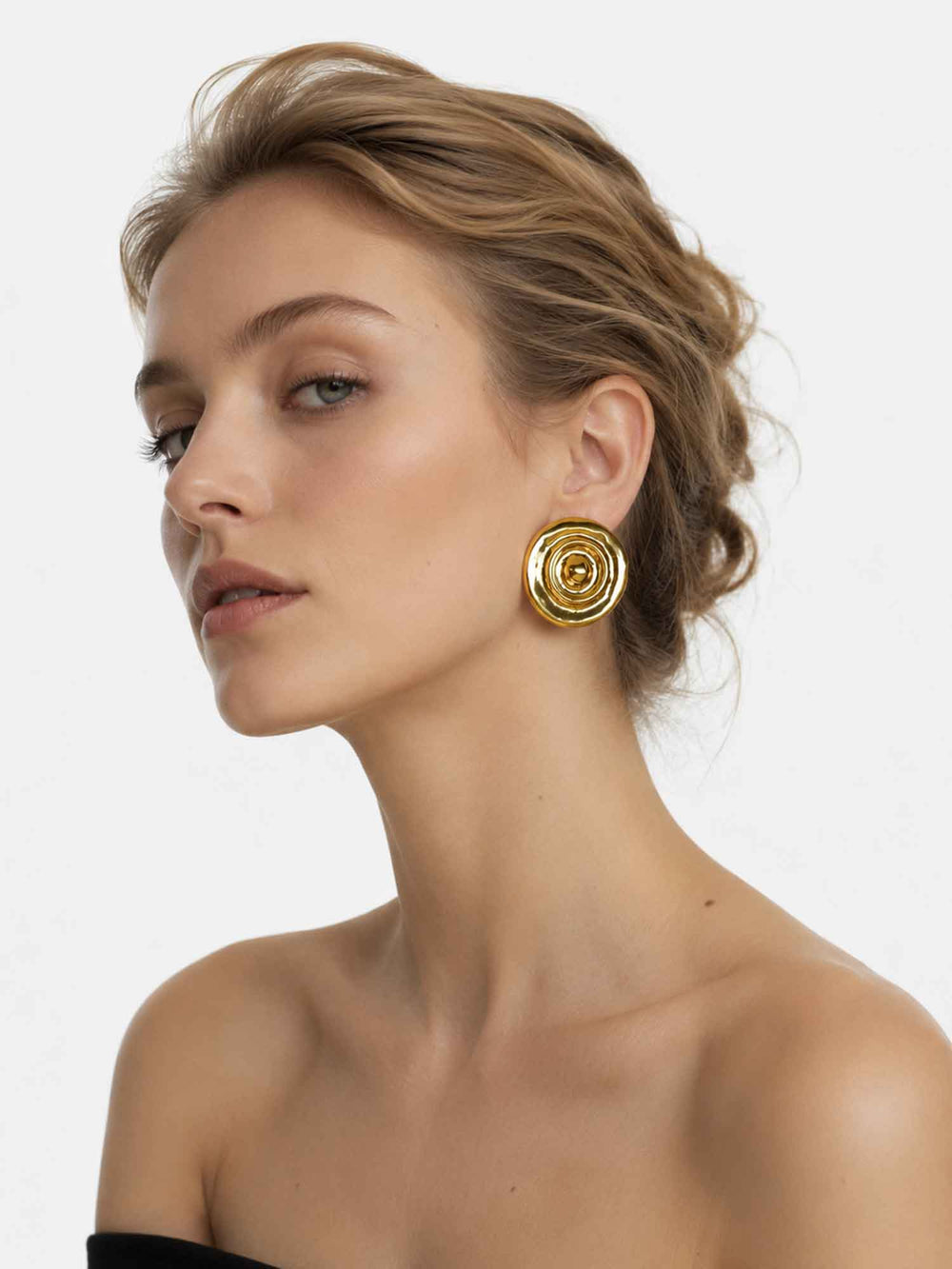 Model wearing Flowing Light gold statement stud earrings with elegant styling