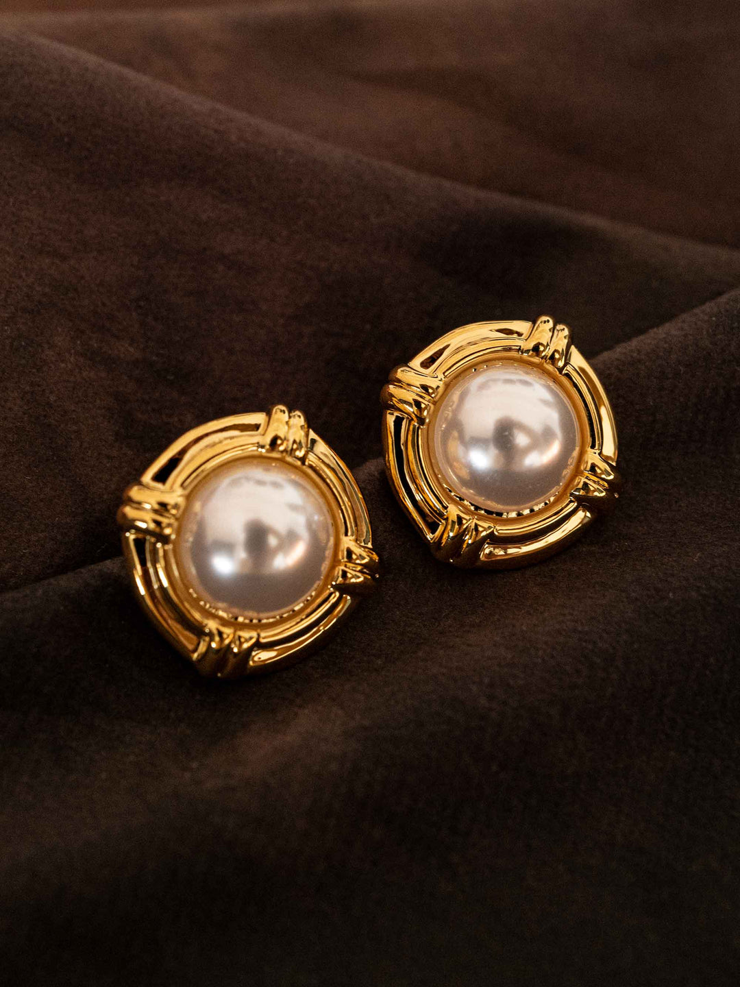 Earrings round pearls vintage goldGold pearl stud earrings styled on dark fabric