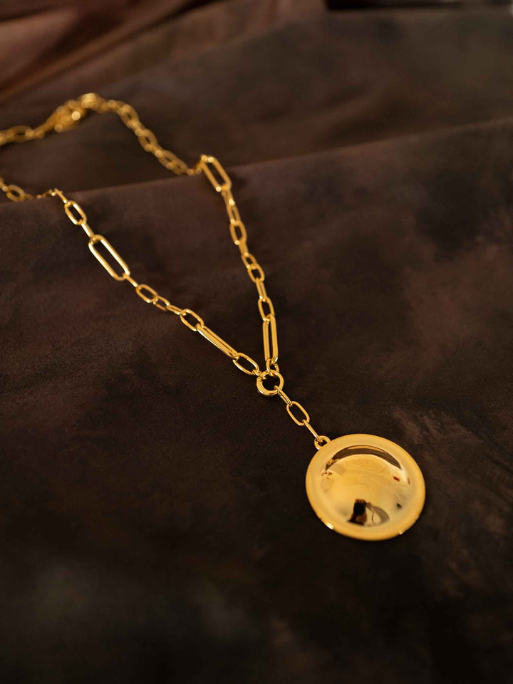 Inez detachable round pendant gold necklace styled on dark fabric