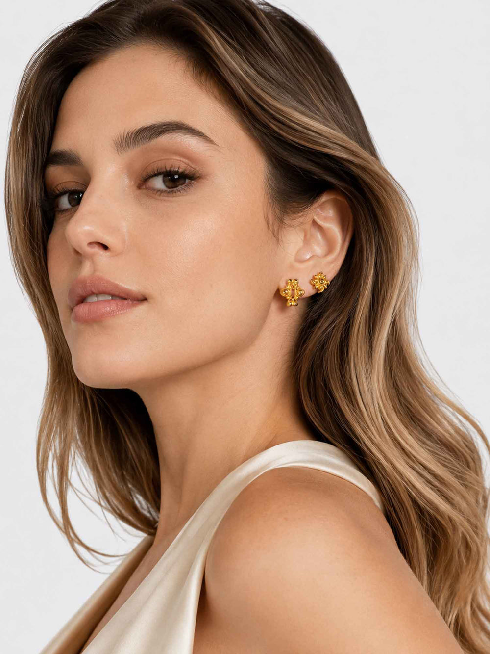 Model wearing Iris floral gold mini hoop earring set with white outfit